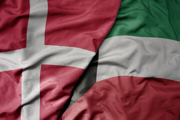 big waving national colorful flag of denmark and national flag of kuwait .