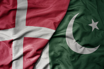 big waving national colorful flag of denmark and national flag of pakistan .