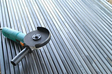 Angle grinder on metal pipes. Metal stripping. Preparing pipes for fence construction.