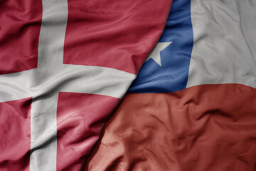 big waving national colorful flag of denmark and national flag of chile .