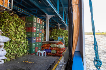 Stacked boxes with tropical fruits, bags and heaps of green bananas on a ferry to Manaus in Brazil,...