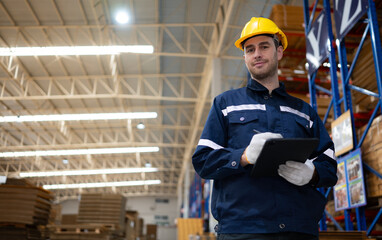 Portrait of confident male warehouse worker with digital tablet in warehouse. This is a paper package storage and distribution warehouse.