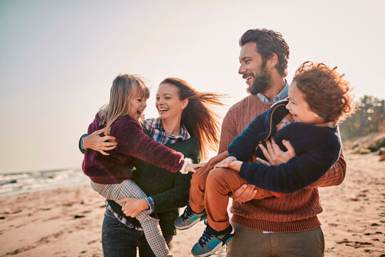 Young happy family walking on a sandy beach during winter