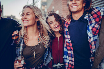 Young and diverse group of friends having a night out in the city and drinking beer