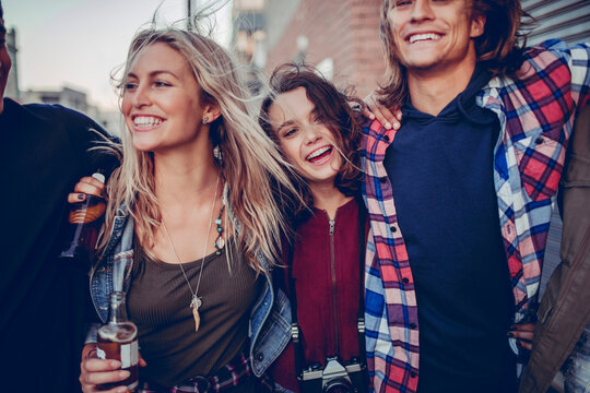 Young and diverse group of friends having a night out in the city and drinking beer