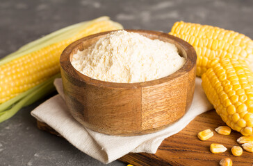 Corn flour with fresh cobs on wooden table