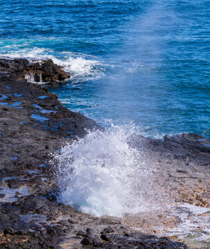 Vent of water from underneath lava rocks on coast of Kauai