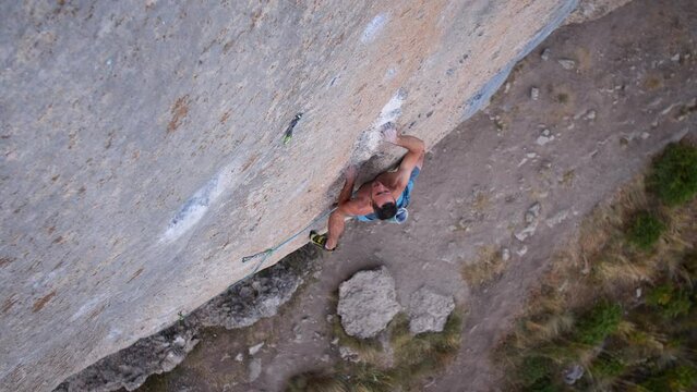 Young man lead climbing a hard and steep section of the wall in C&eacute;&uuml;se, France.
Following camera movement, low angle, 4K.