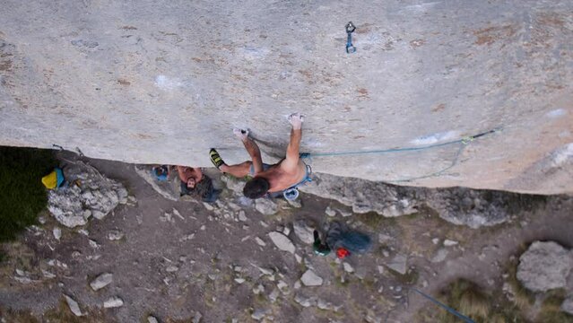 Young man lead climbing a hard and steep section of the wall in C&eacute;&uuml;se, France.
Following camera movement, low angle, 4K.