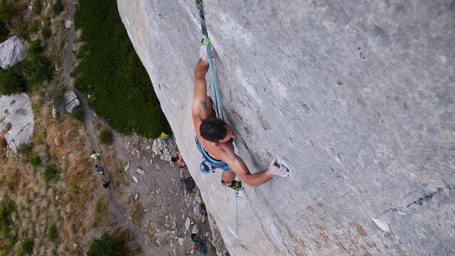 Young man lead climbing a hard and steep section of the wall in C&eacute;&uuml;se, France.
Following camera movement, low angle, 4K.