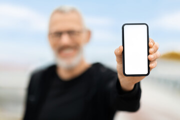 Phone with white empty screen in retired sportsman hand