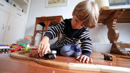 Boy Playing with Vintage Train Set at Home, Close-up of Kid's Hand with Retro Toy Railroad
