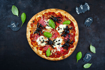 Traditionelle italienische Halloween Spinnen Pizza mit Salami, Mozzarella und Oliven serviert als...