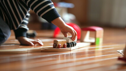 Close-up of Kid's Hand with Retro Toy Railroad, Boy Playing with Vintage Train Set at Home - obrazy, fototapety, plakaty