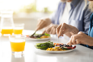 Breakfast Time. Unrecognizable Mature Couple Eating Morning Meal In Kitchen