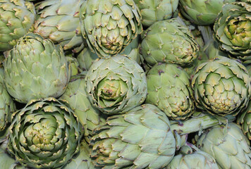 Fototapeta premium background of green large ripe artichokes for sale at market