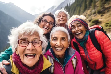 Zelfklevend Fotobehang Group of senior women hiking with friends on the mountain, having fun together, taking selfie photo © pilipphoto