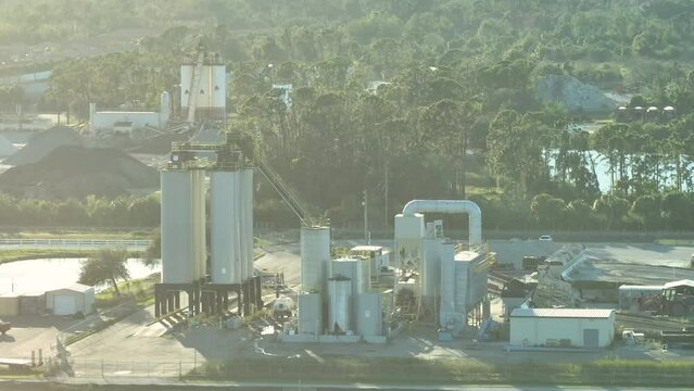 Concrete mixing factory at industrial area with cement trucks and heavy building equipment