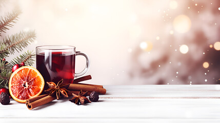 A glass of mulled wine on a winter boken background, copy space. Warming drink based on red wine. Glass of hot red wine with spices, red orange, cinnamon stick and anise stars. Mulled wine ads banner
