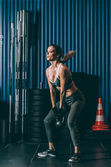 Fototapeta na wymiar Fit woman training working out lifting kettlebell in Gym