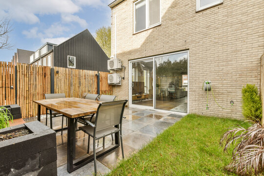 Patio with table and chairs outside modern house