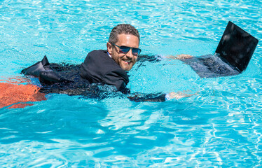 Remote working. Summer business dreams. successful man. Businessman in suit with laptop in swimming pool. business man on summer vacation. businessman in wet suit in swim pool. agile business