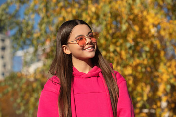 Autumn teen girl wearing in sunglasses and looks stylish. Fall season. Girl dreams in autumn fall. Autumn mood of adolescent model. Autumn leaves in park outdoor. fall fashion
