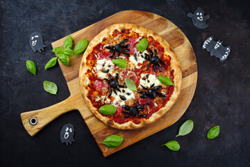 Traditionelle italienische Halloween Spinnen Pizza mit Salami, Mozzarella und Oliven serviert als...