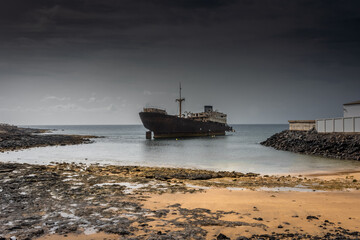 The Telamon shipwreck on the sea under a cloudy sky in Lanzarote Island , Spain