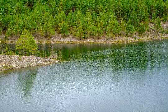 This is a former shale quarry with azure water and picturesque hills. Unlike the Narva shale settling ponds. A dark autumn day. Estonia, Aidu quarry.