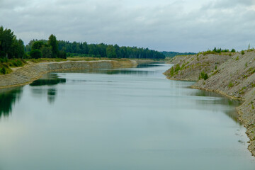 This is a former shale quarry with azure water and picturesque hills. Unlike the Narva shale settling ponds. A dark autumn day. Estonia, Aidu quarry.