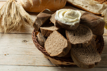 slices of dark bread on a basket. also known as australian bread. one of them have cream cheese