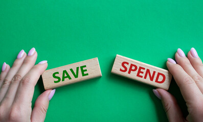 Save or Spend symbol. Concept word Save or Spend on wooden blocks. Businessman hand. Beautiful green background. Business and Save or Spend concept. Copy space