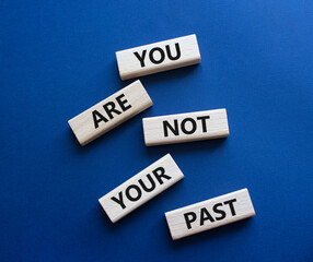 You are not your past symbol. Wooden blocks with words You are not your past. Beautiful deep blue background. Business and You are not your past. Copy space.