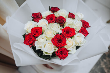 Large, beautiful packaged bouquet of many red, white roses close-up. Photography of nature.