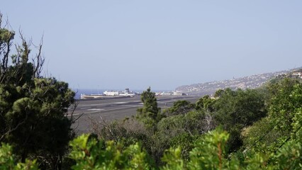 Hill view of the plane landing at Madeira Airport International Cristiano Ronaldo on sunny day
