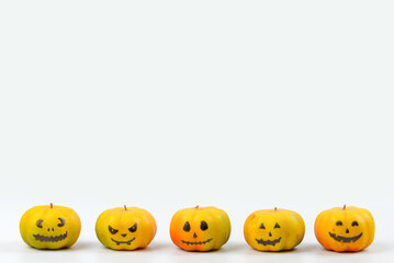 Halloween pumpkin decor with funny faces on a white background with space for text