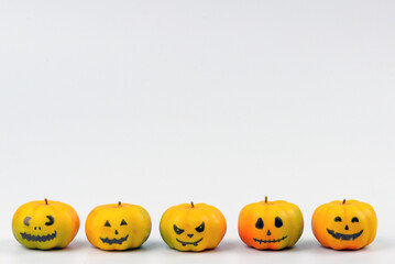 Halloween pumpkin decor with funny faces on a white background with space for text