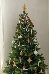 Stylish decorated christmas tree with vintage golden baubles and candles. Atmospheric winter...