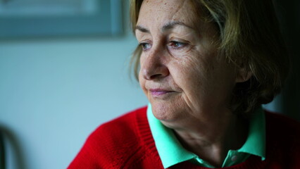 Pensive senior woman close-up face with thoughtful expression. Contemplative elderly lady in deep...