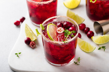 Christmas cranberry and lime margarita cocktail garnished with lime zest
