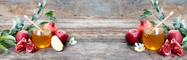 rosh hashana holiday - honey jar with apples and pomergranates on rustic background