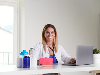 female doctor working on desktop with laptop computer