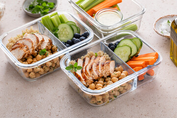 High protein healthy lunch meal prep in containers with chicken, quinoa, herbed chickpeas, vegetables and eggs