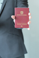 An unrecognizable executive man holding a Colombia passport. Business trip. Identification...