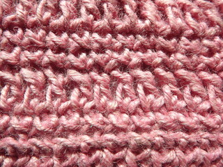 A sample crocheted from pink jute close-up on a gray background