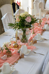 .Beautiful flowers decorated the table. Tables are set for a party or wedding reception. luxury elegant dinner setting in restaurant with candles.