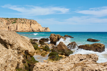 Fototapeta na wymiar Huge cliffs and limestone rocks washed by the ocean waves. Lagos, Portugal