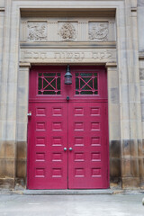 Obraz premium Red front doors to an old synagogue in Glasgow, Scotland on sunny morning. 