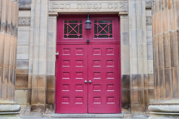 Red front doors to an old synagogue in Glasgow, Scotland on sunny morning. 